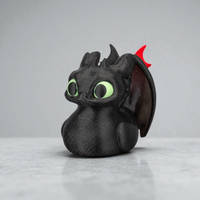 Toy figure of a dragon with green eyes and red horn on a gray background