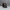 Black dragon figurine with green eyes and red horns on a gray background